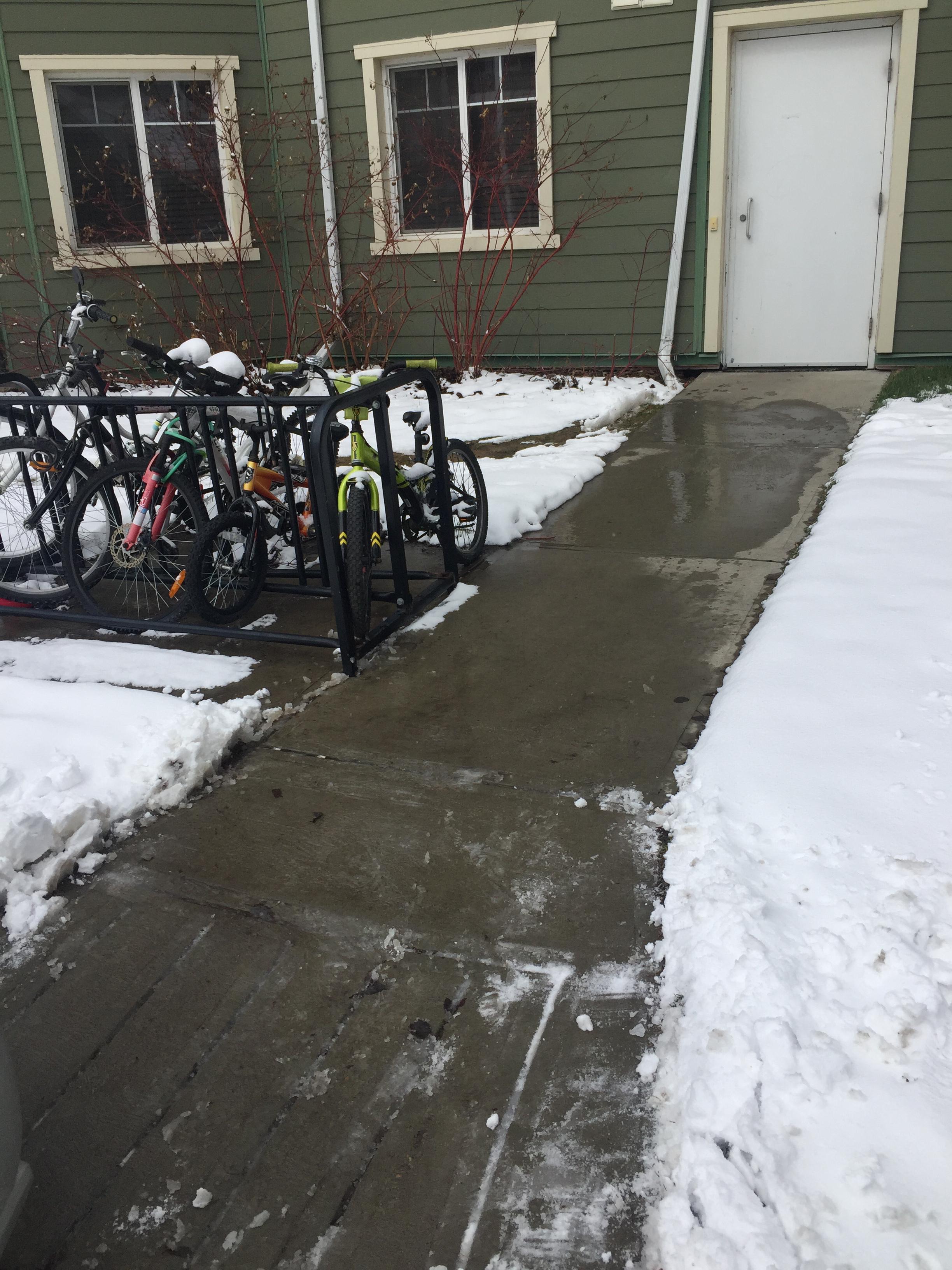 Apartment building walkway and entrance cleared of snow